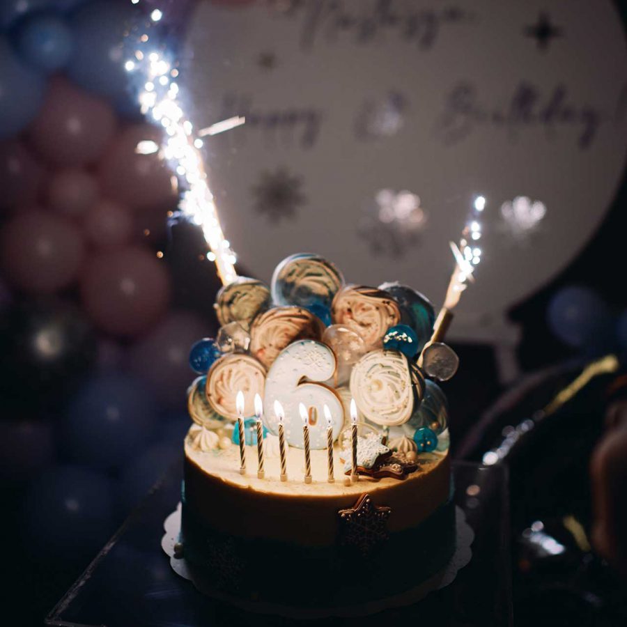 Festive birthday cake with candles and fireworks. Caption: 6